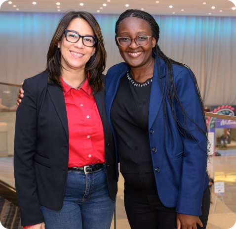 Two professional women smiling at a networking event